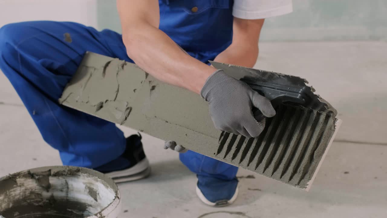 Installing ceramic floor tiles - measuring and cutting the pieces. Construction, renovation, repair apartment. Cuts tile. Tile cutting