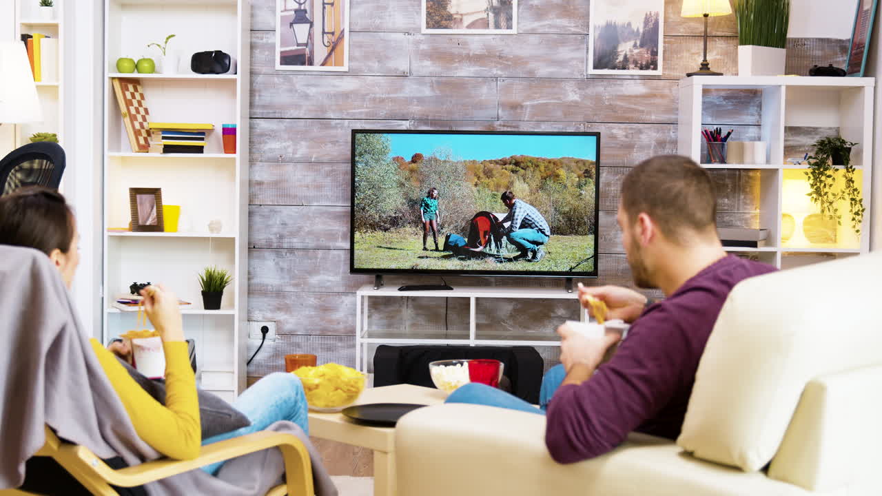 Couple Watching TV and Eating in Living Room