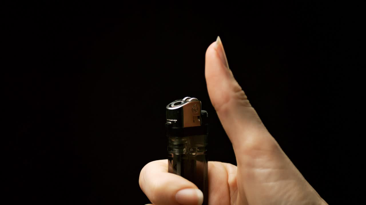 la gracia de encendido: ser testigo del momento encantador como chispas florecen en llamas de una mano que sostiene un encendedor, capturado en hipnotizante cámara lenta