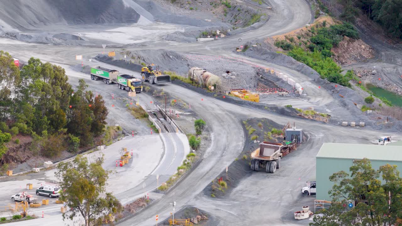 Drone footage captures vehicles and machinery at a quarry in Gold Coast, Australia, highlighting industrial activity and landscape