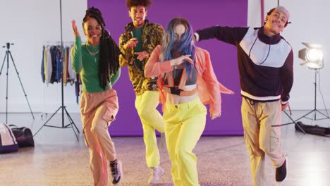 portrait of happy diverse male and female dancers dancing in dance studio, slow motion