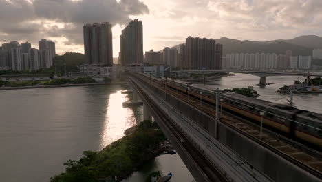 mtr train drives over a girder bridge towards tsing yi, hong kong