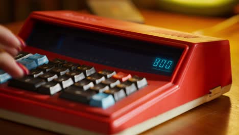 persona que usa una vieja calculadora roja