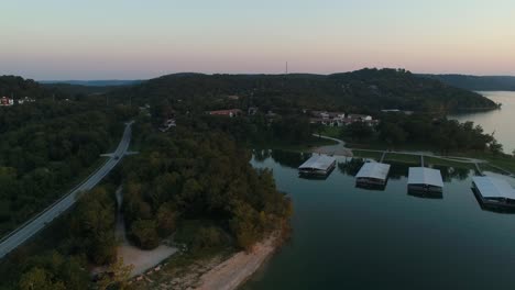 Luftaufnahme-über-Einem-Seehafen-Und-Seitlicher-Flug,-Um-Eine-Straße-Durch-Ein-Waldgebiet-Zu-Zeigen