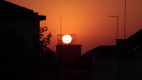 silhouettes of houses and buildings on a fiery sunset in nazare, portugal