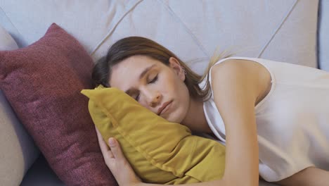 una mujer joven cansada o aburrida y somnolienta cae en el sofá.