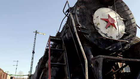 old train engine with a red star on the front, camera pans down