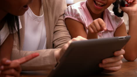 Teacher-looking-at-tablet-with-pupils