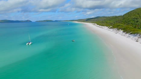 Boats-anchored-at-whitehaven-beach,-filmed-with-a-drone