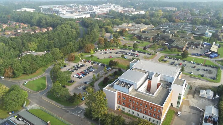 Vista aérea ascendente sobre o estacionamento de hospital britânico - edifícios médicos
