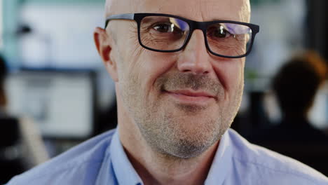 close-up view of caucasian middle aged man in glasses smiling at the camera in the office