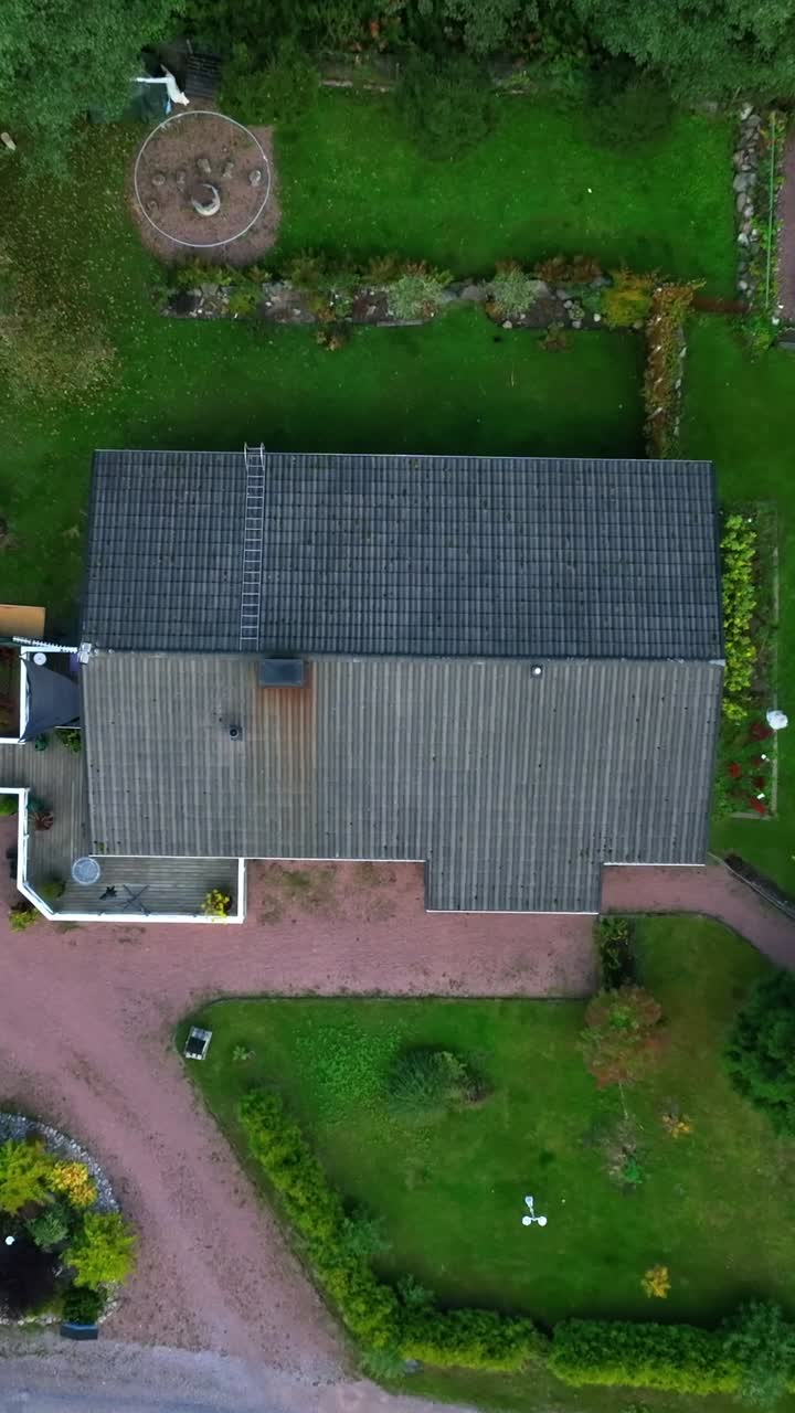 Vertical drone shot descending above a detached house, autumn day in Finland