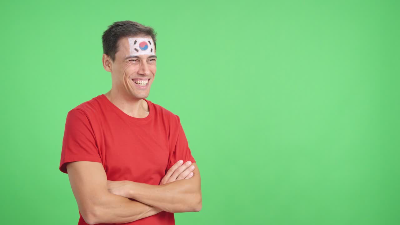Happy man with south korean flag painted on face looking away