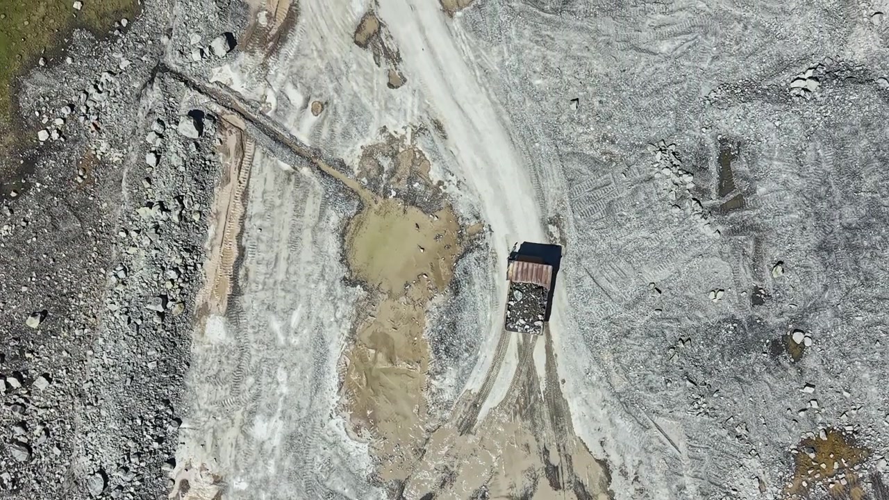 Granite quarry operations in a large excavation site during daylight hours showing heavy machinery at work