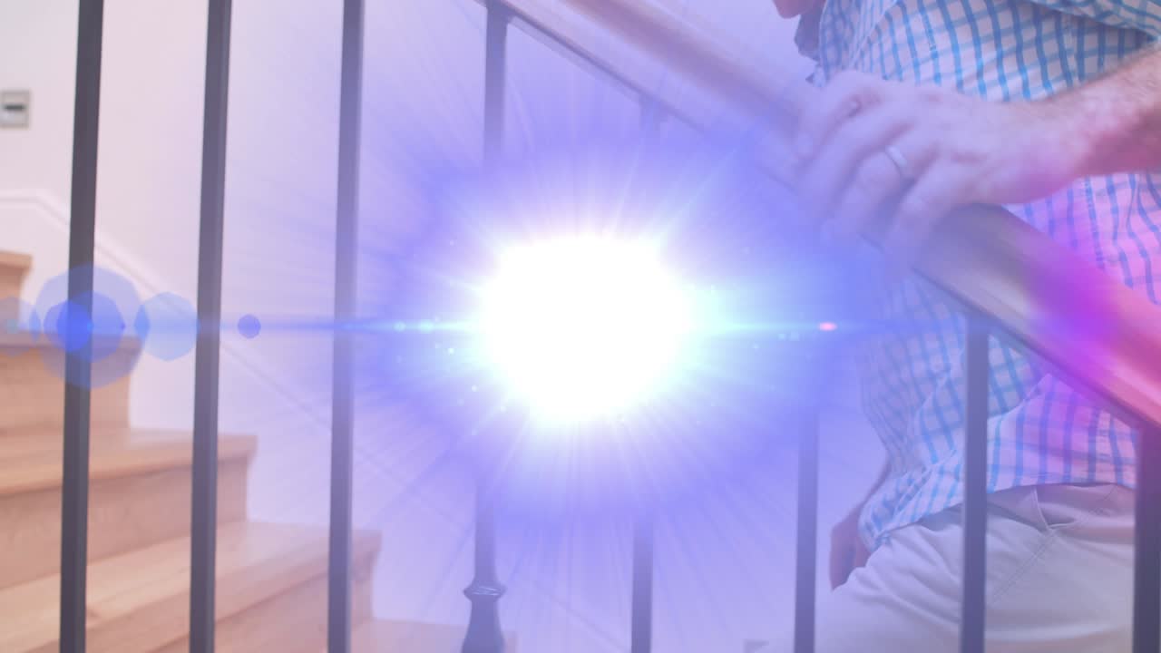 계단 위로 걸어가는 바니스터를 들고 있는 고위 남자의 중간 부분을 가로지르는 빛의 애니메이션