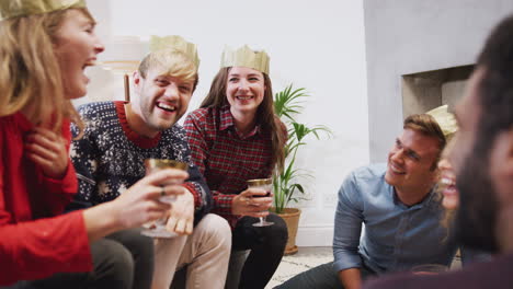 grupo de amigos celebrando con champán y hablando después de disfrutar de la cena de navidad en casa