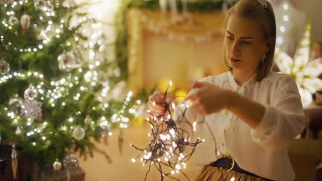 woman in cozy interior arranges christmas lights