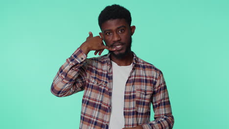 Cheerful-african-american-man-looking-at-camera-doing-phone-gesture-like-says-hey-you-call-me-back