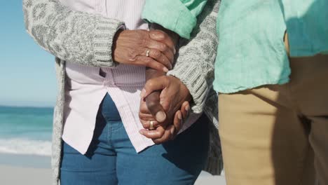 senior couple walking besides the beach