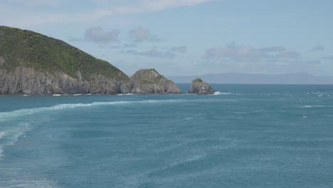 View-from-ship-onto-coast,-rocks-and-ocean-in-Cook's-Strait,-New-Zealand