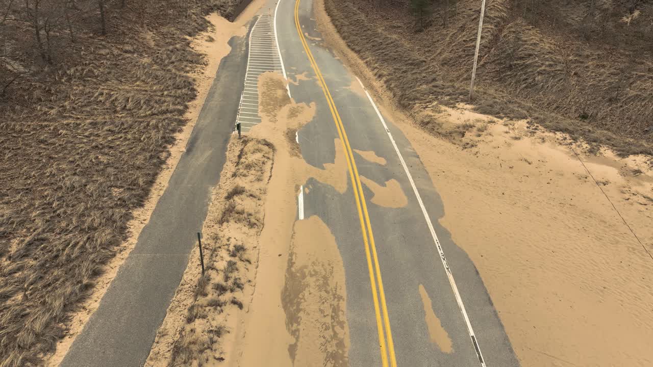 movimiento hacia adelante a lo largo de una carretera invernada cubierta de arena por los fuertes vientos