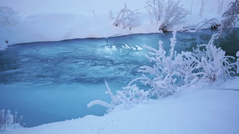 frozen river with snow around in the winter time
