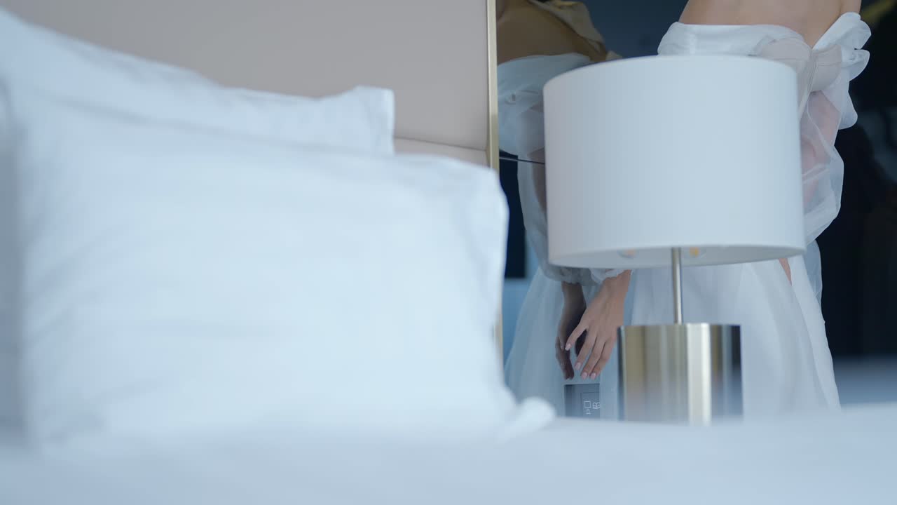 여자 한 명 이 호텔 방 에서 옷 을 입고 있다