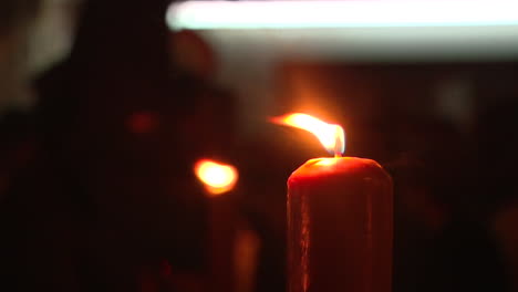 burning red candle in the dark