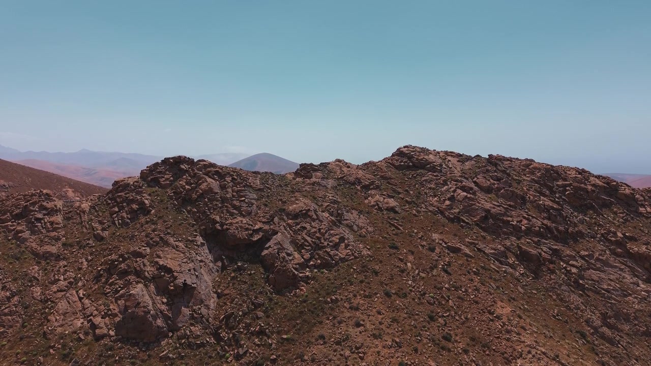 Veduta aerea di una aspra cresta montuosa sotto un cielo azzurro e limpido