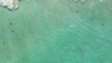 Ein-Blick-Auf-Das-Meer-Von-Oben-Auf-Einen-Strand-Mit-An-Der-Küste-Brechenden-Wellen