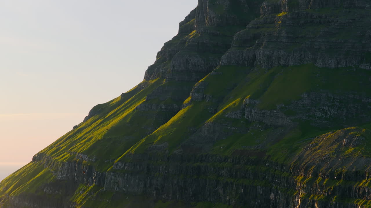 Sunlit Green Slopes of a Majestic Mountain Cliff