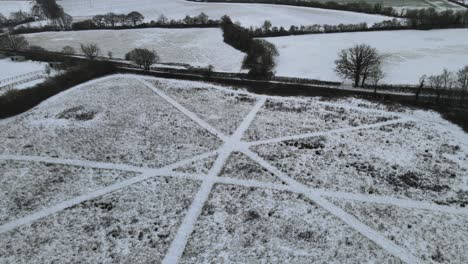 Snow-covered-landscape-with-abstract-paths-aerial-pan-4k