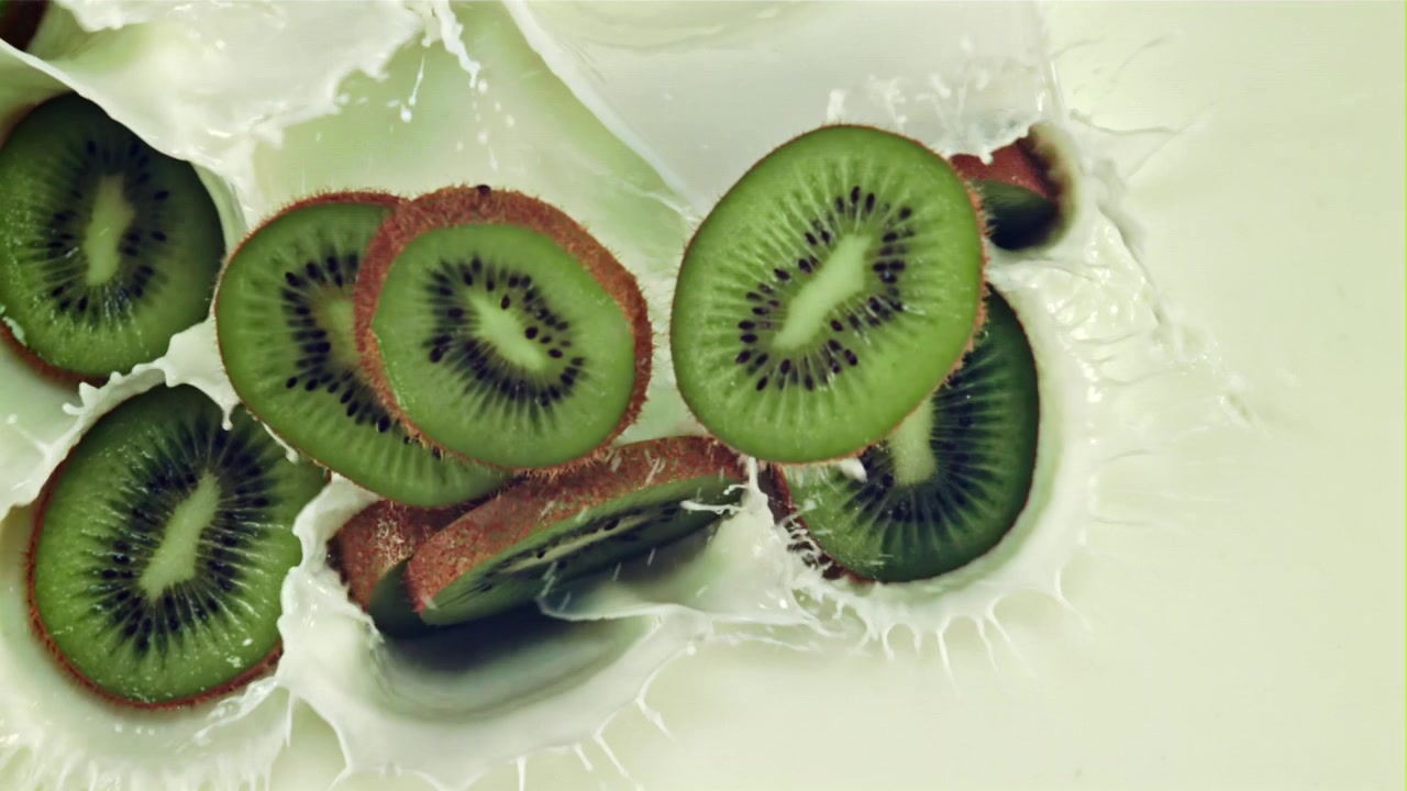 Rodajas de Kiwi Fresco Salpicando en Leche Cremosa a Cámara Lenta