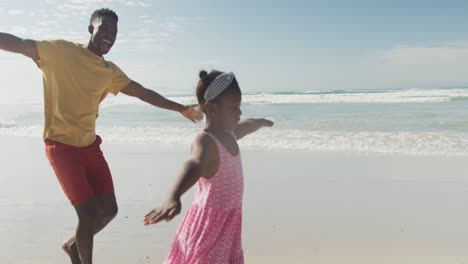 Padre-E-Hija-Afroamericanos-Con-Los-Brazos-Abiertos-Disfrutando-En-La-Playa