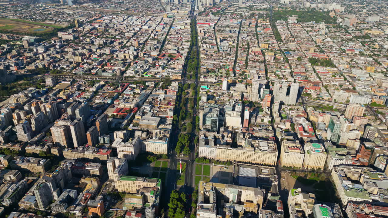 Aerial drone view of central Santiago showcasing government buildings, parks, and a grid of city streets bathed in sunlight