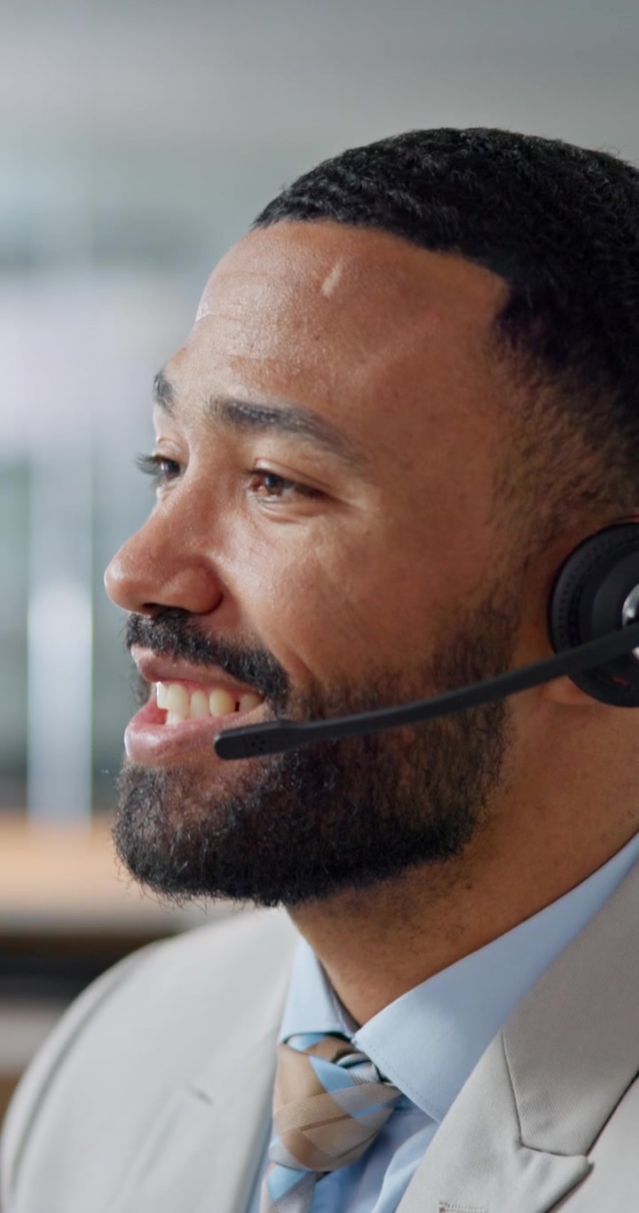 Operatore professionale del servizio clienti che parla al telefono con cuffie in ufficio