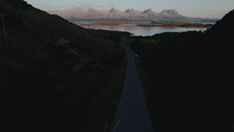 de syv sostre - seven sisters mountain range from dark empty road in nordland, norway. - aerial tilt up