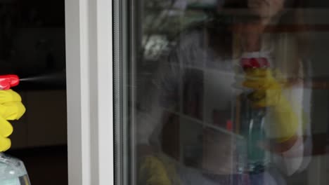 mujer joven lavando la ventana en casa, concepto de limpieza de primavera