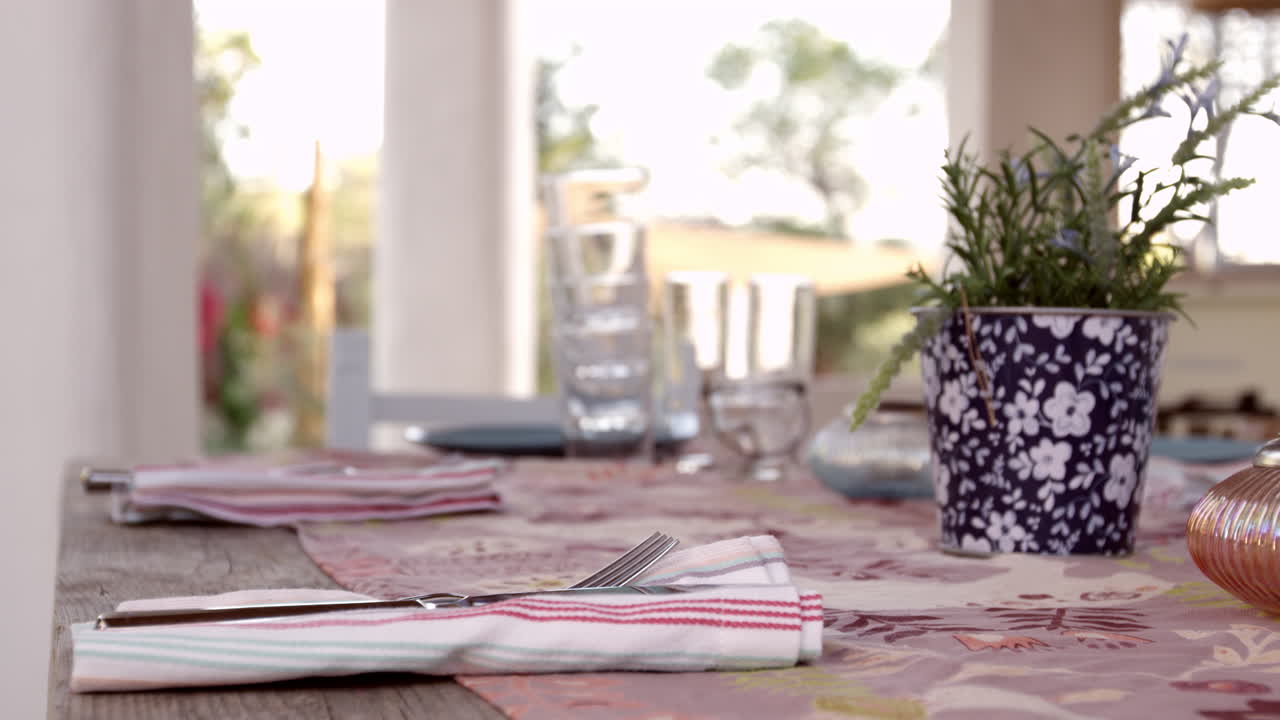 fotografía a nivel de la mujer preparando la mesa de la cena en el patio, tomada en r3d