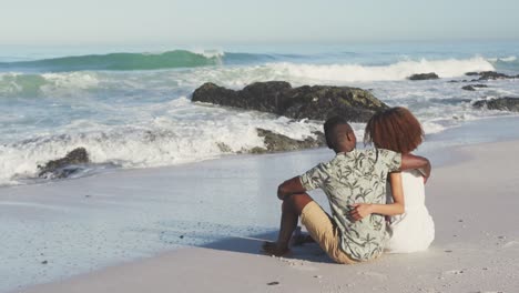 african american couple sitting in front of the sea