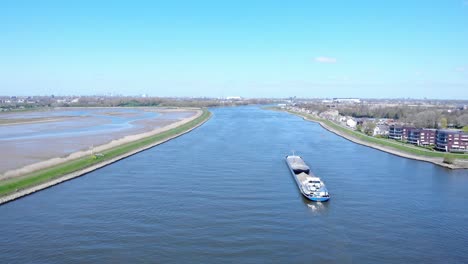 Vista-Aérea-De-La-Barcaza-En-El-Río-Noord-Bajo-Un-Cielo-Azul-Brillante-Durante-El-Día-Cerca-De-Hendrik-ido-ambacht,-Países-Bajos