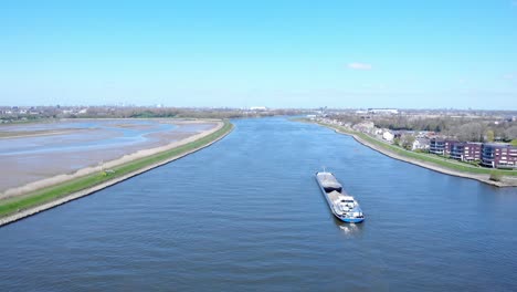vista aérea de la barcaza en el río noord bajo un cielo azul brillante durante el día cerca de hendrik-ido-ambacht, países bajos