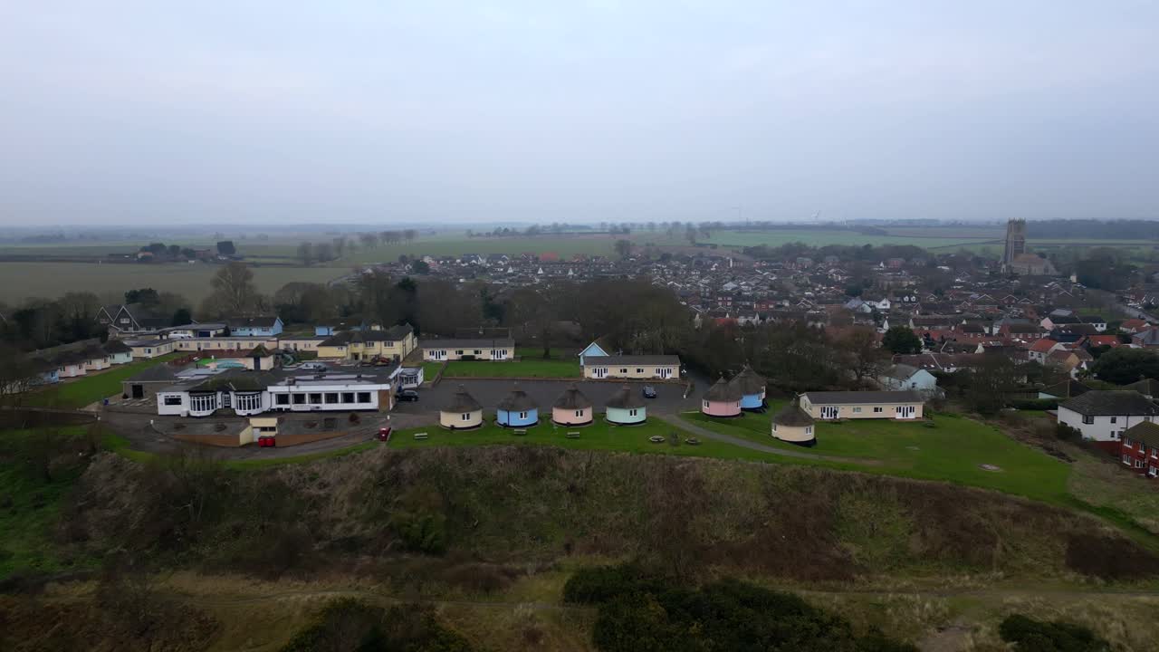 Drone flies toward Hermanus Holiday Park with countryside and village in view