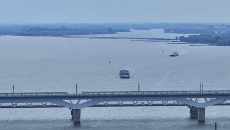 train crossing moerdijk bridges with cargo boats