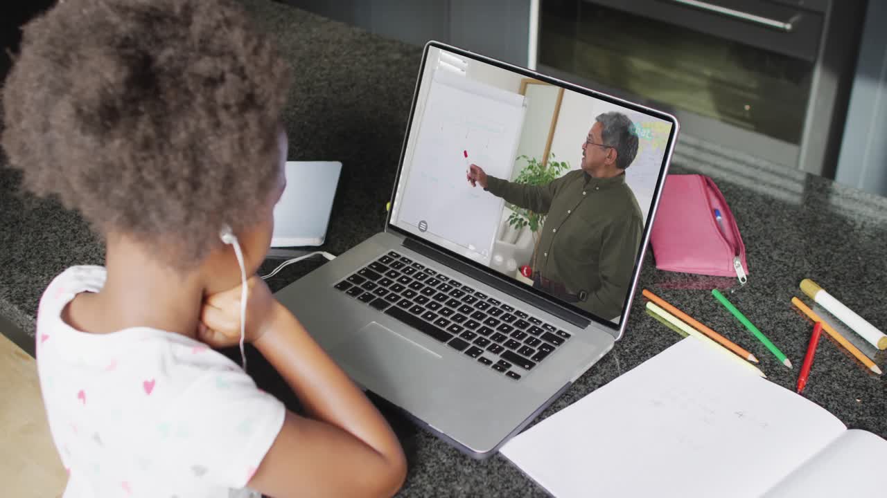 African american girl using laptop for video call, with male teacher on screen