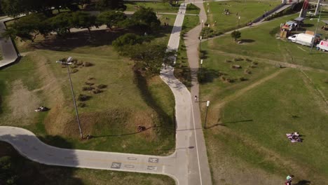 Drone-following-shot-of-young-girl-skating-on-road-at-Park-during-sunny-day-in-Buenos-Aires