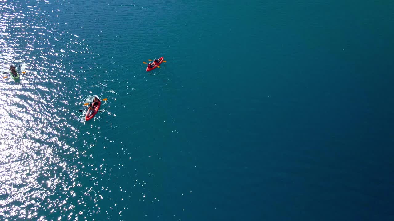 Aerial orbit of three kayaks in Laguna del Inca, Chile