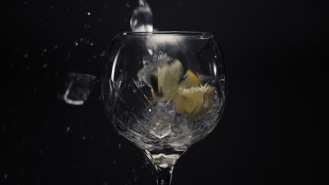 ice cubes lemons falls empty wineglass closeup. refreshing drink concept