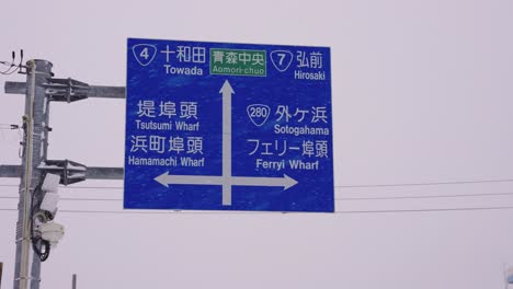 Ferry-Wharf-Road-Sign-at-Aomori-Bay,-Snowing-in-Northern-Japan