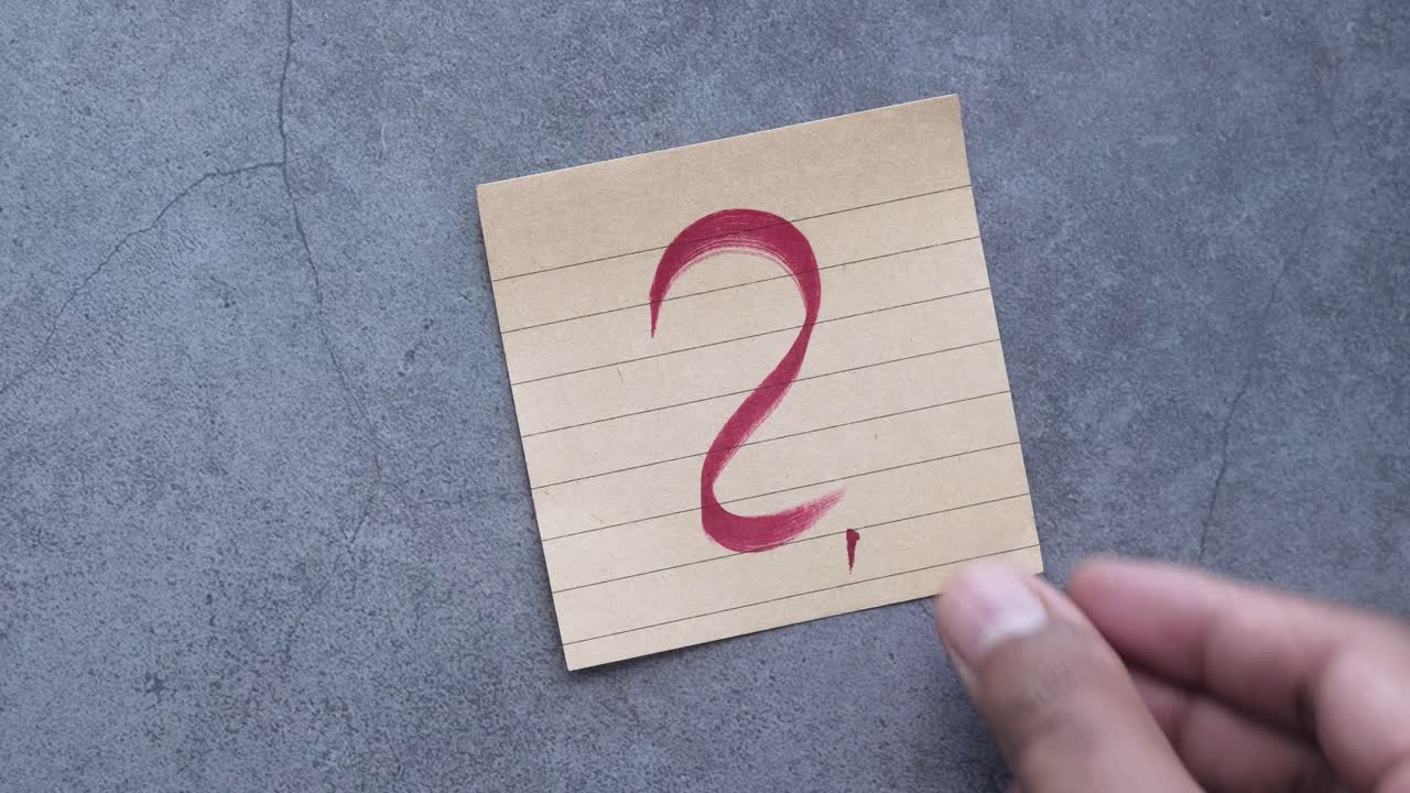 mano sosteniendo una nota con el número dos